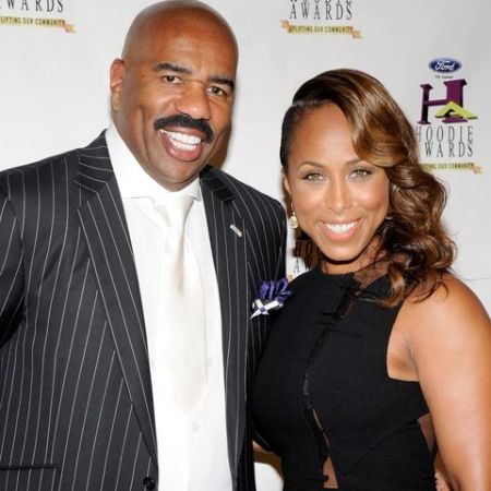 Steve Harvey in a black coat poses a picture with wife Marjorie Bridges-Wood.